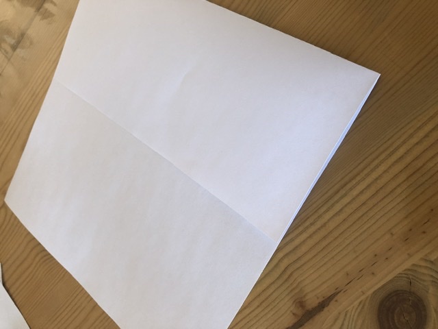 Bild zum Schritt 4 für die Kinder-Beschäftigung: 'Blatt Papier umdrehen, dass die bemalte/ bedruckte Seite auf dem...'
