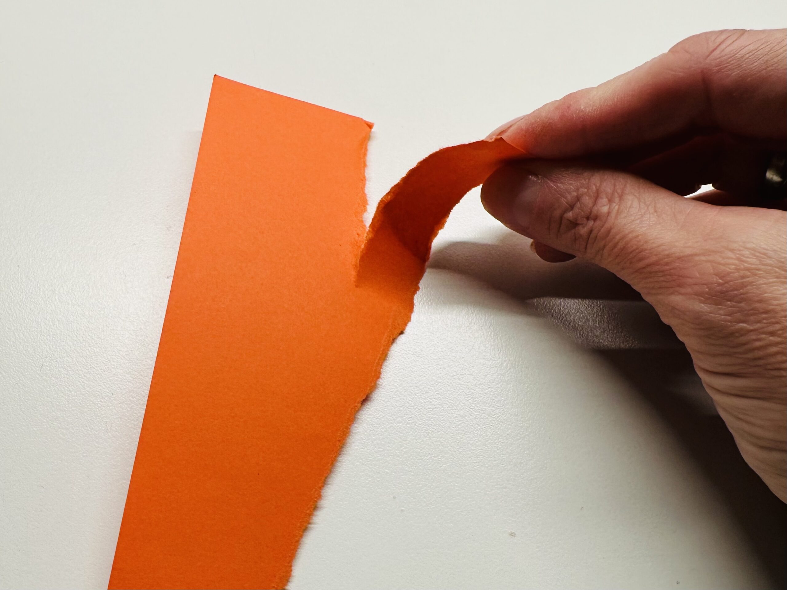 Bild zum Schritt 2 für das Bastel- und DIY-Abenteuer für Kinder: 'Reißt das Tonpapier in spitz zulaufende Streifen. Das werden die...'