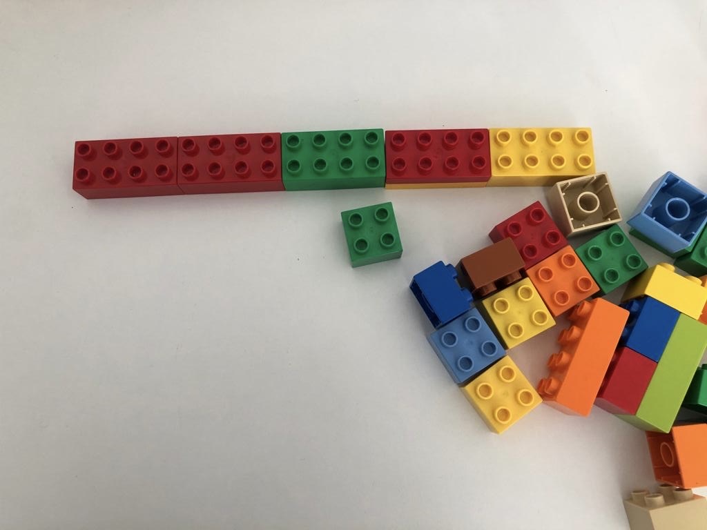 Bild zum Schritt 2 für das Bastel- und DIY-Abenteuer für Kinder: 'Beginnt damit eine Reihe aus Legosteinen zu legen. Die Länge...'