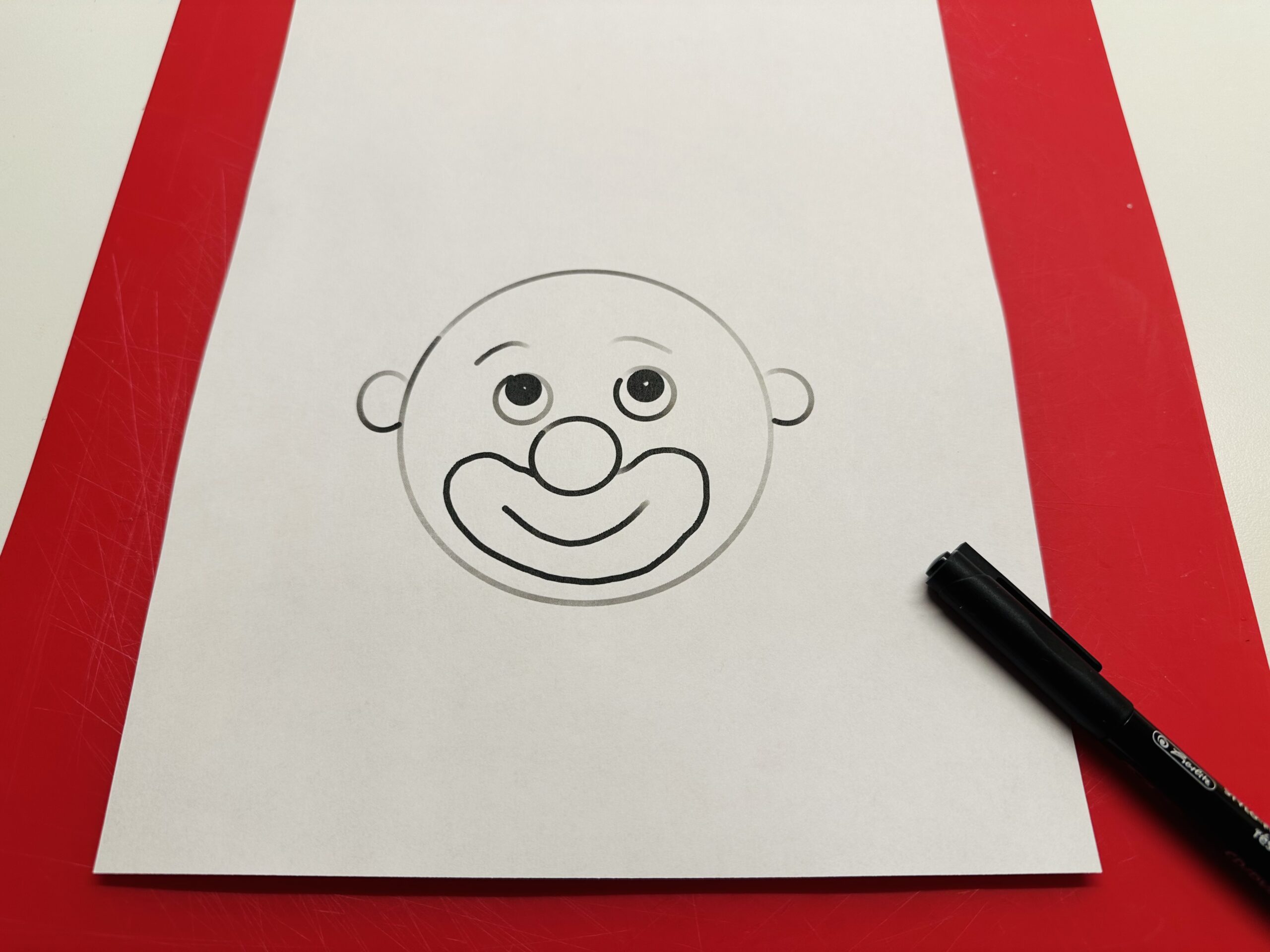Bild zum Schritt 2 für das Bastel- und DIY-Abenteuer für Kinder: 'Malt zuerst ein Gesicht oder einen Clownkopf, ohne Haare, auf...'