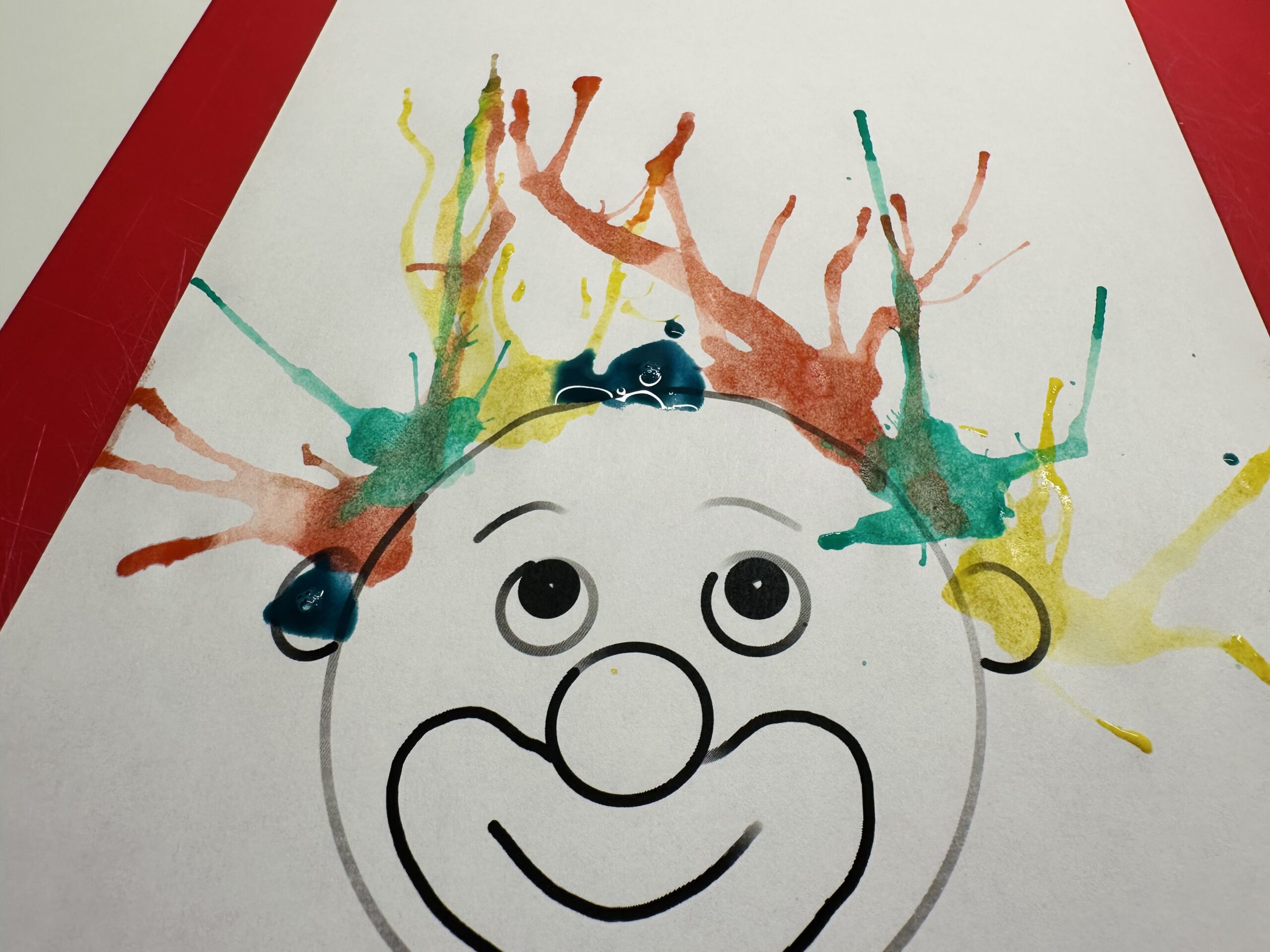 Bild zum Schritt 12 für das Bastel- und DIY-Abenteuer für Kinder: 'Macht so lange weitere Farbkleckse bis euer Clowngesicht ganz viele...'
