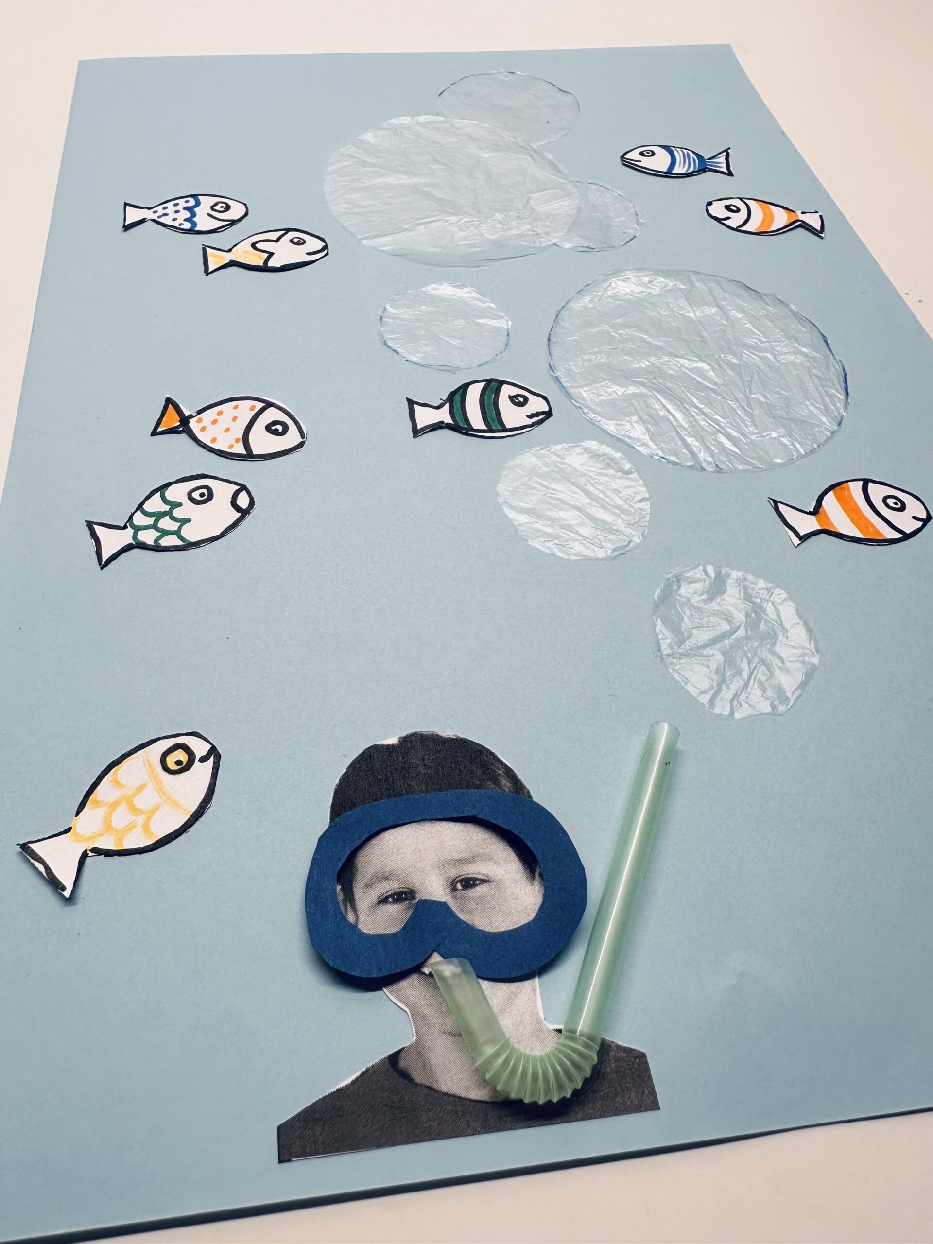 Bild zum Schritt 32 für das Bastel- und DIY-Abenteuer für Kinder: 'Wenn euch die Anordnung gefällt, klebt alle Luftblasen und Fische...'