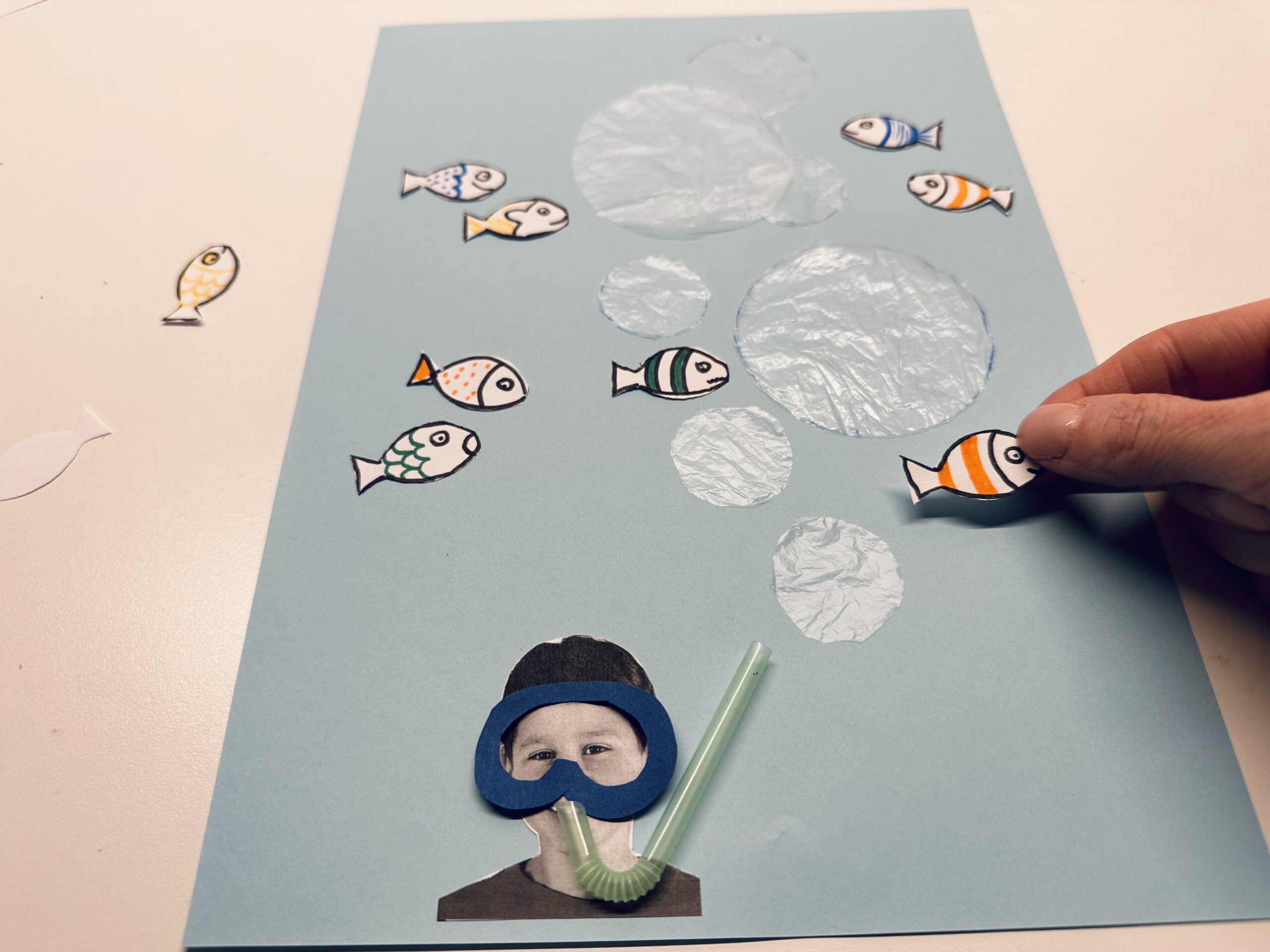 Bild zum Schritt 31 für das Bastel- und DIY-Abenteuer für Kinder: 'Ordnet die fertigen Fische auf eurem Bild an. So, als...'