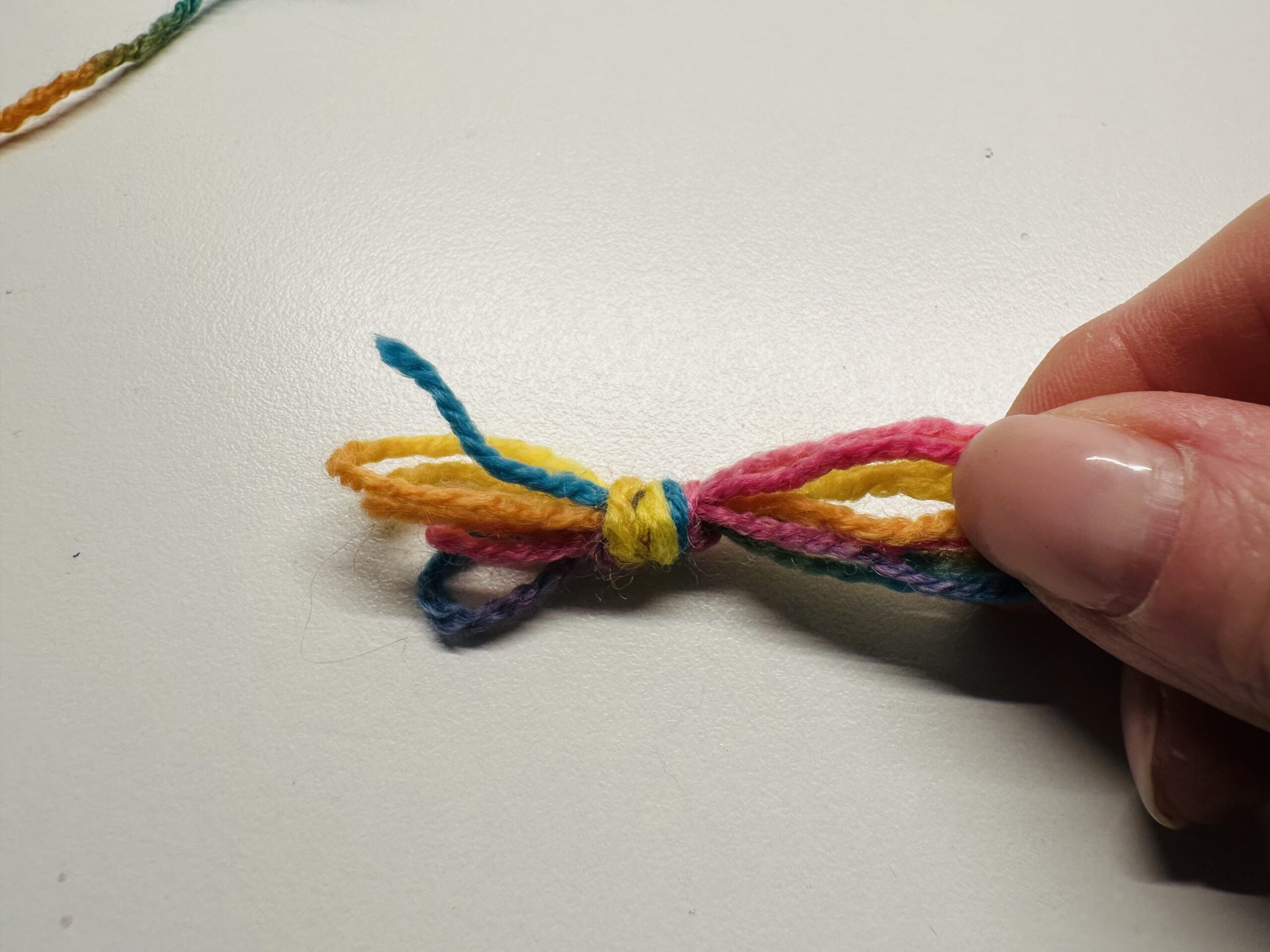 Bild zum Schritt 6 für das Bastel- und DIY-Abenteuer für Kinder: 'Auch am anderen Ende müsst ihr einen Knoten machen.'