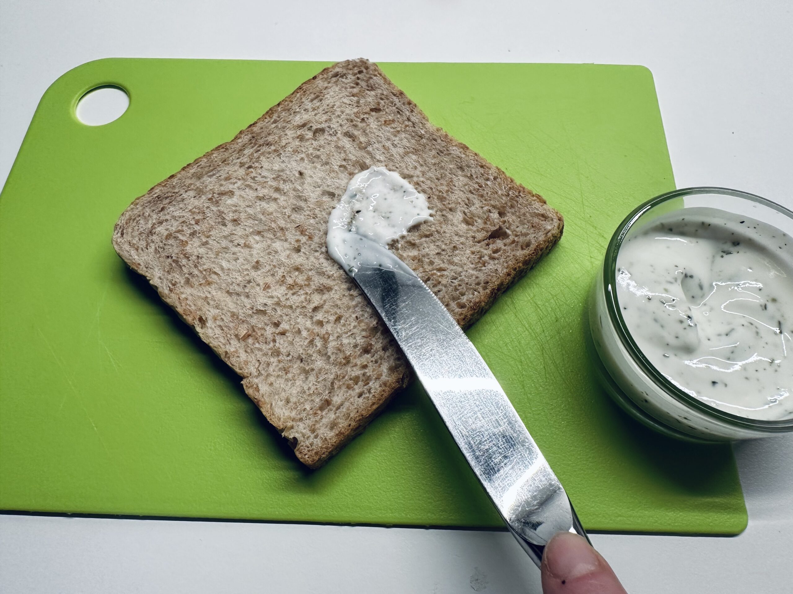 Bild zum Schritt 3 für das Bastel- und DIY-Abenteuer für Kinder: 'Bestreicht das Toastbrot mit Frischkäse.'