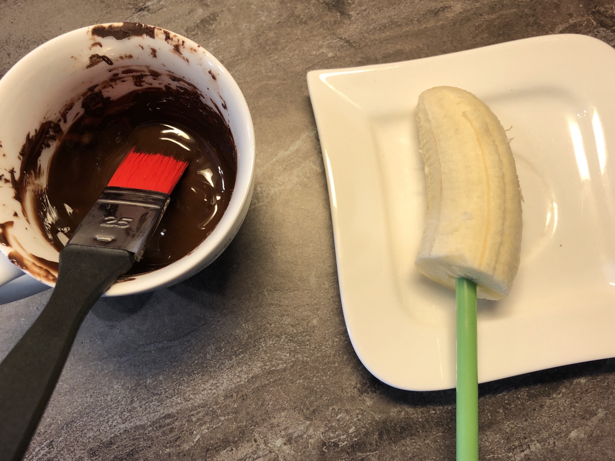 Bild zum Schritt 4 für das Bastel- und DIY-Abenteuer für Kinder: 'Mit einem Pinsel die Banane mit Schokolade überziehen.'