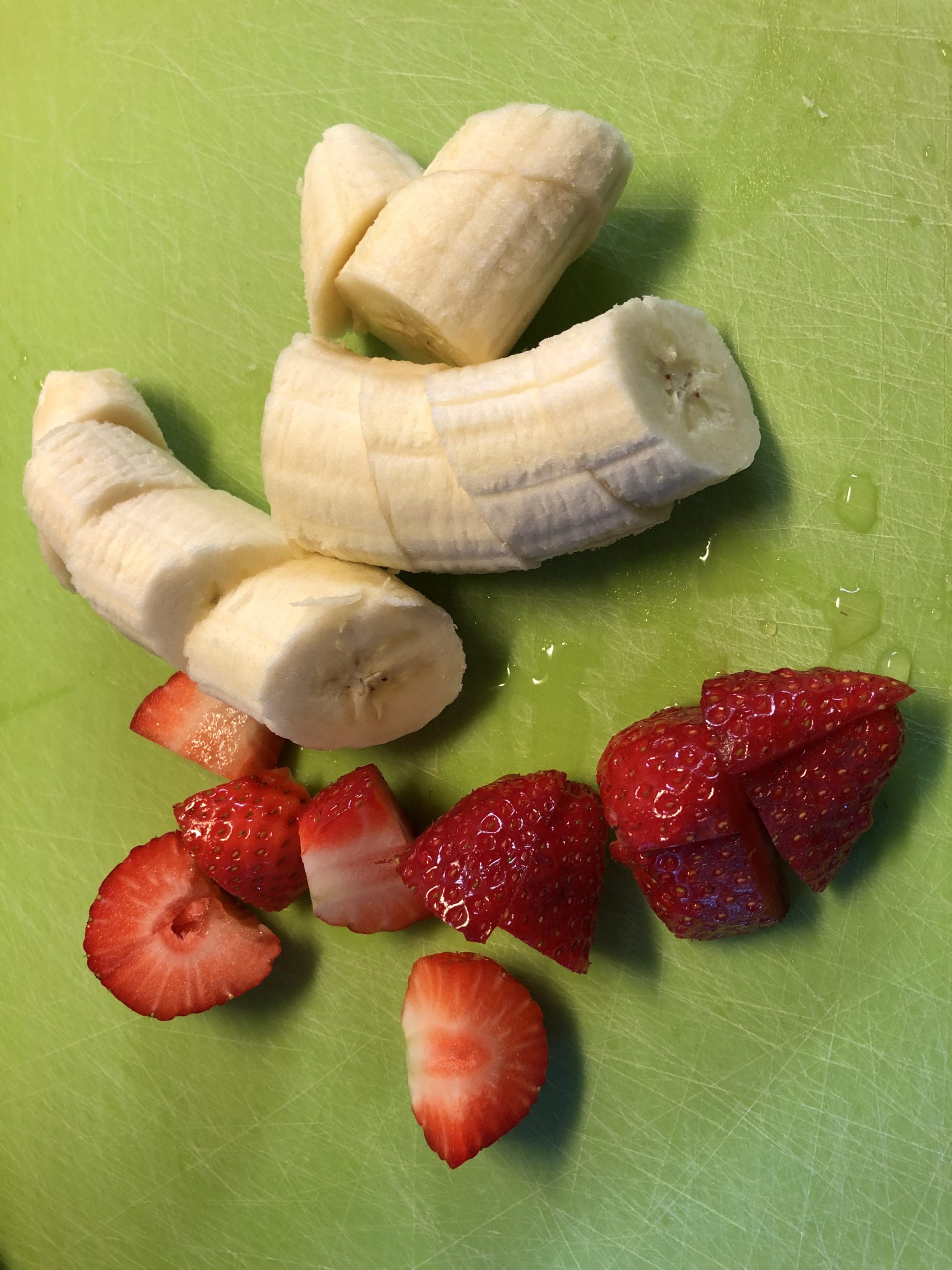 Bild zum Schritt 2 für die Kinder-Beschäftigung: 'Erdbeeren und Banane grob in Stücke schneiden.'
