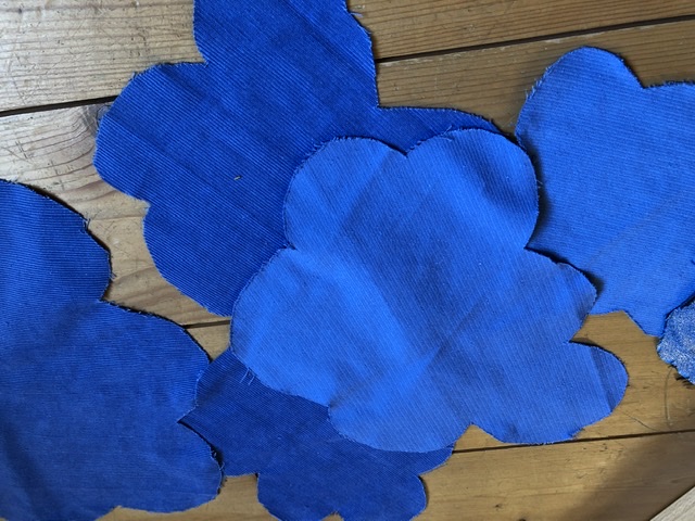 Bild zum Schritt 21 für das Bastel- und DIY-Abenteuer für Kinder: 'Wolken in verschiedenen Größen und aus verschiedenen blauen Stoffen ausschneiden.'