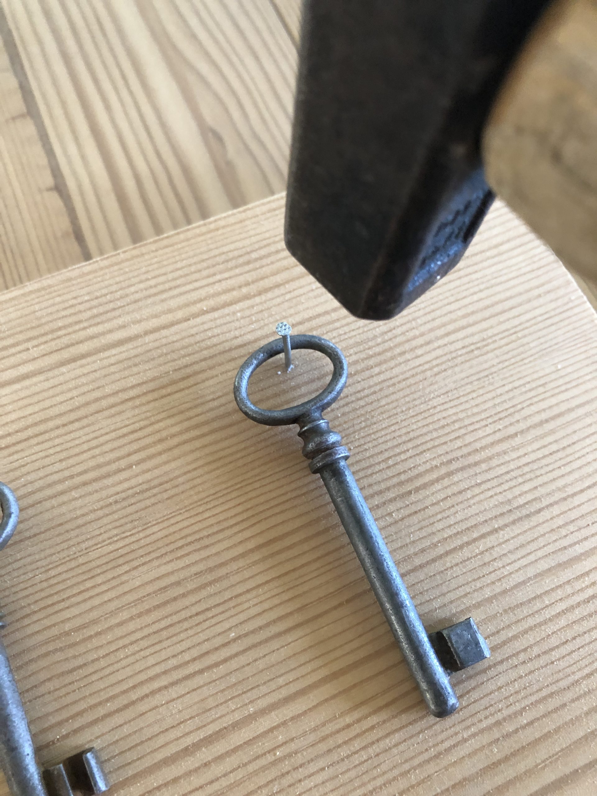 Bild zum Schritt 5 für das Bastel- und DIY-Abenteuer für Kinder: 'Nun werden die Schlüsselhacken befestigt. Dazu einen  Nagel mittig...'