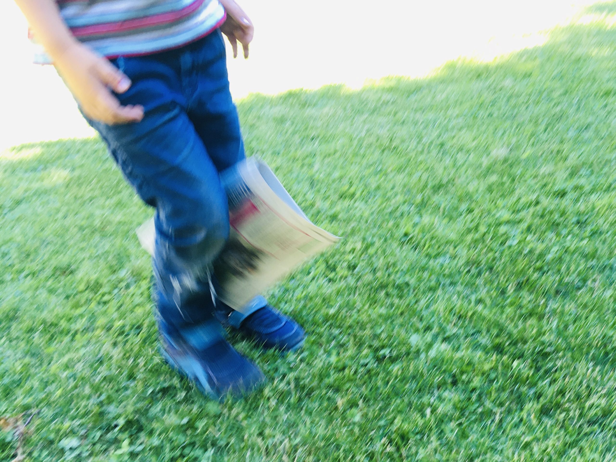 Bild zum Schritt 2 für die Kinder-Beschäftigung: 'Sich mit dem Zeitungspapier fortbewegen, ohne die Zeitung mit den...'