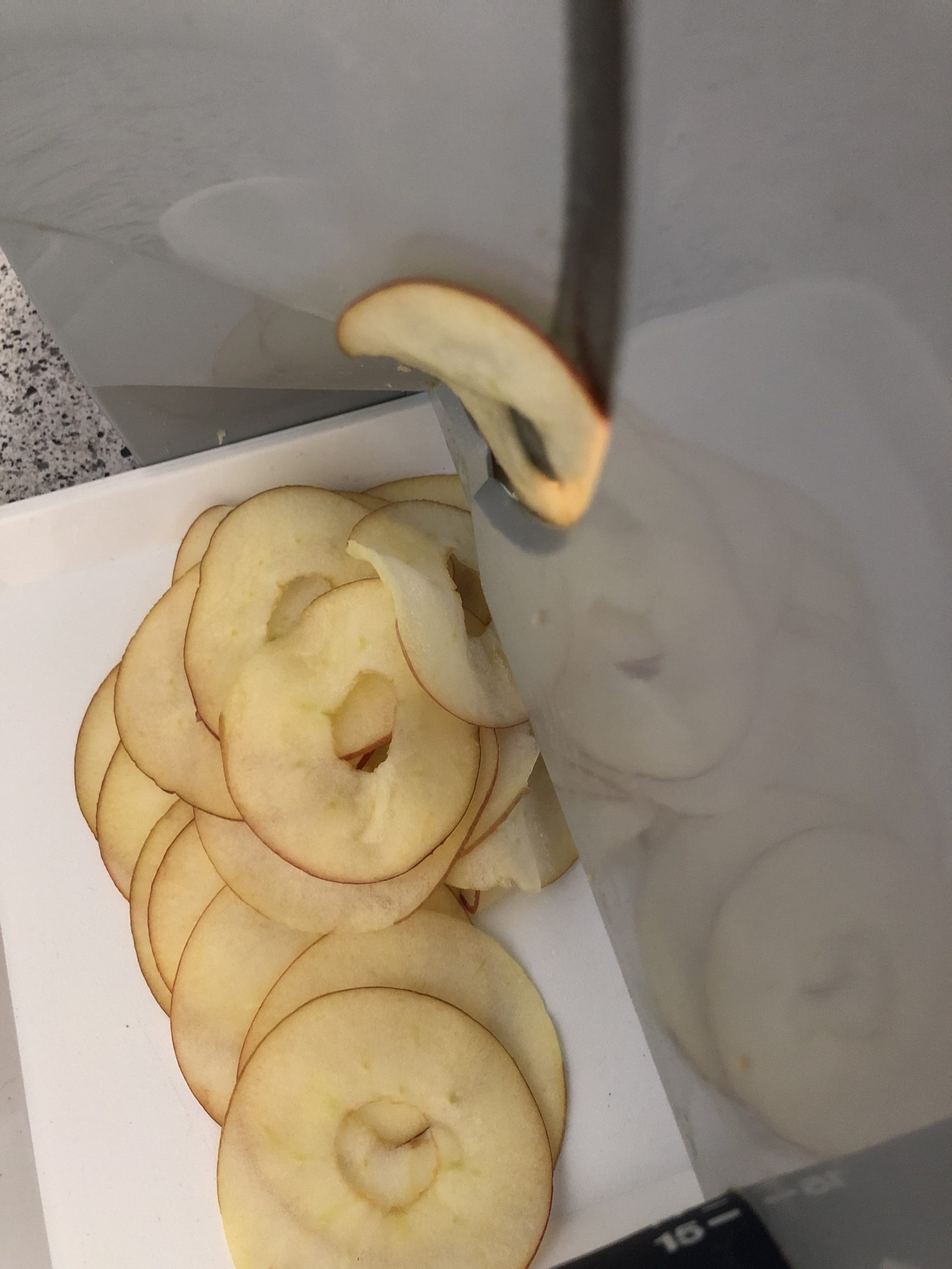 Bild zum Schritt 2 für die Kinder-Beschäftigung: 'Den Apfel mit der Brotschneidemaschine in hauchdünne Scheiben schneiden. ...'