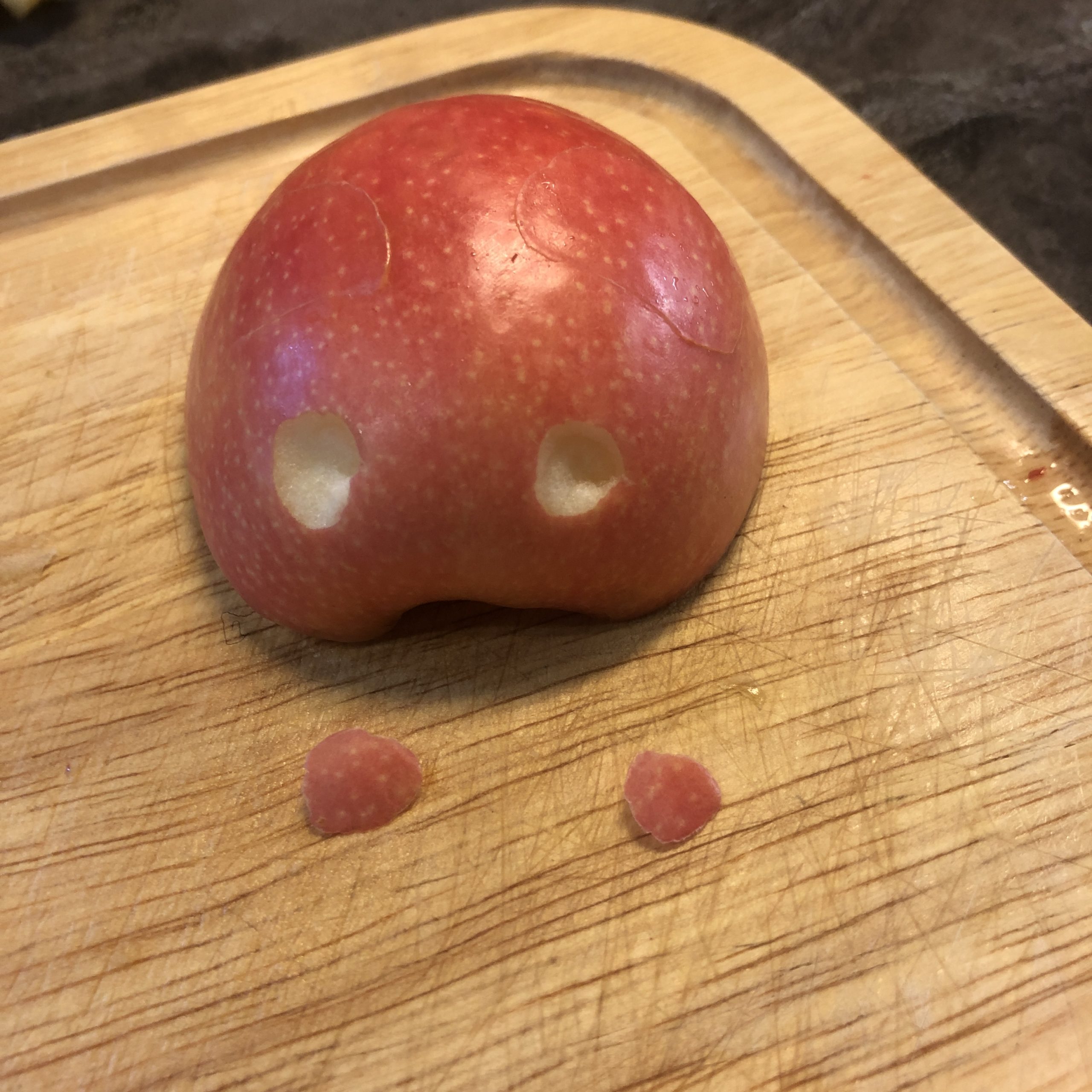 2. Bild zum Schritt 6 für das Bastel- und DIY-Abenteuer für Kinder: 'Mit der Messerspitze werden an einer Apfelhälfte zwei kleine „Augen“...'
