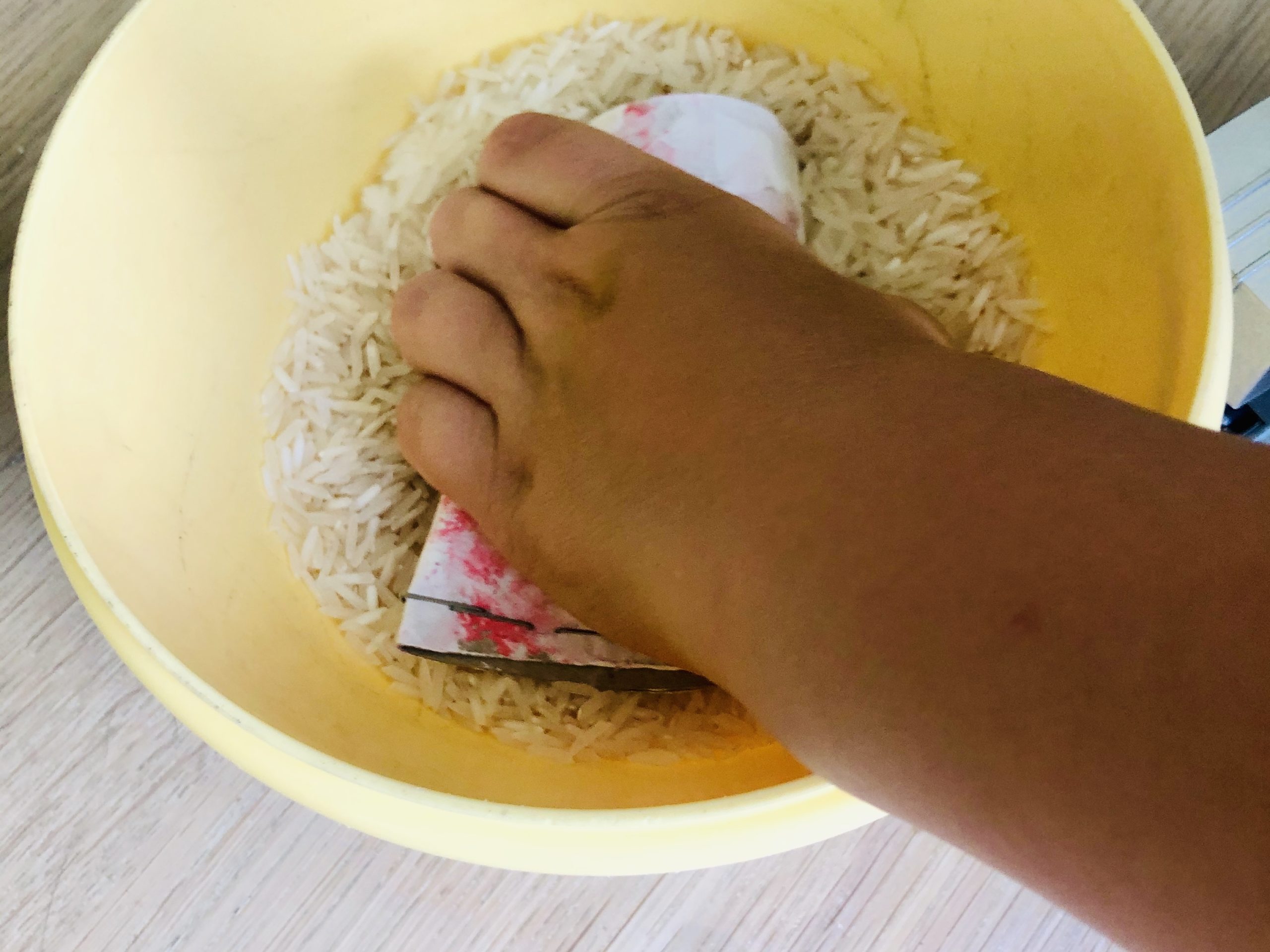 Bild zum Schritt 6 für die Kinder-Beschäftigung: 'Jetzt Reis einfüllen. Befüllt dabei maximal die Hälfte der Klorolle.'