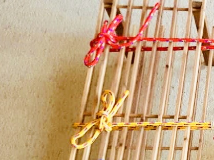 Bild zum Schritt 2 für das Bastel- und DIY-Abenteuer für Kinder: 'Dann bindet die Seile in einem gleichen Abstand um die...'
