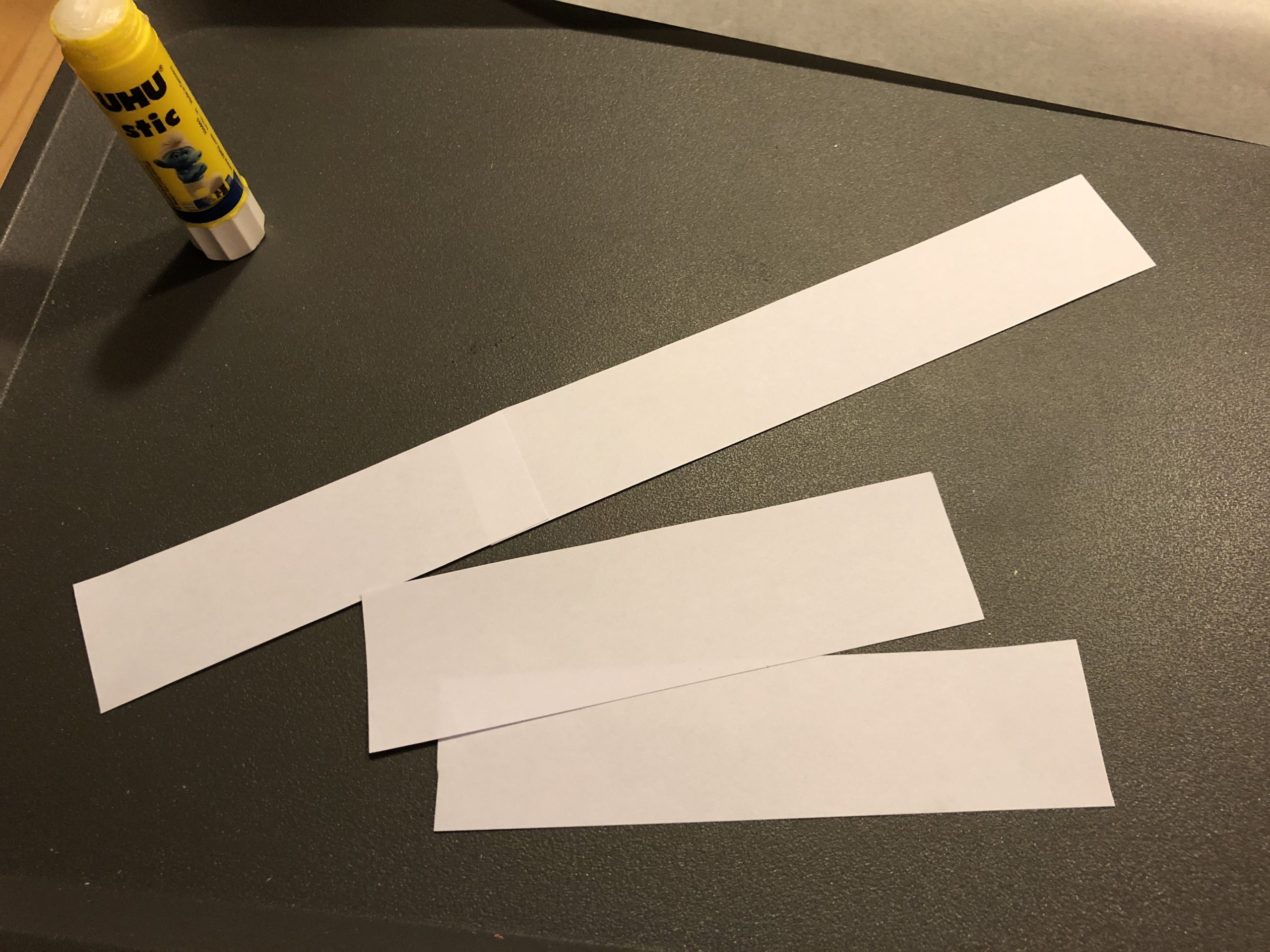 Bild zum Schritt 6 für das Bastel- und DIY-Abenteuer für Kinder: 'Schneidet euch Streifen aus weißem Papier aus, dass ihr zum...'