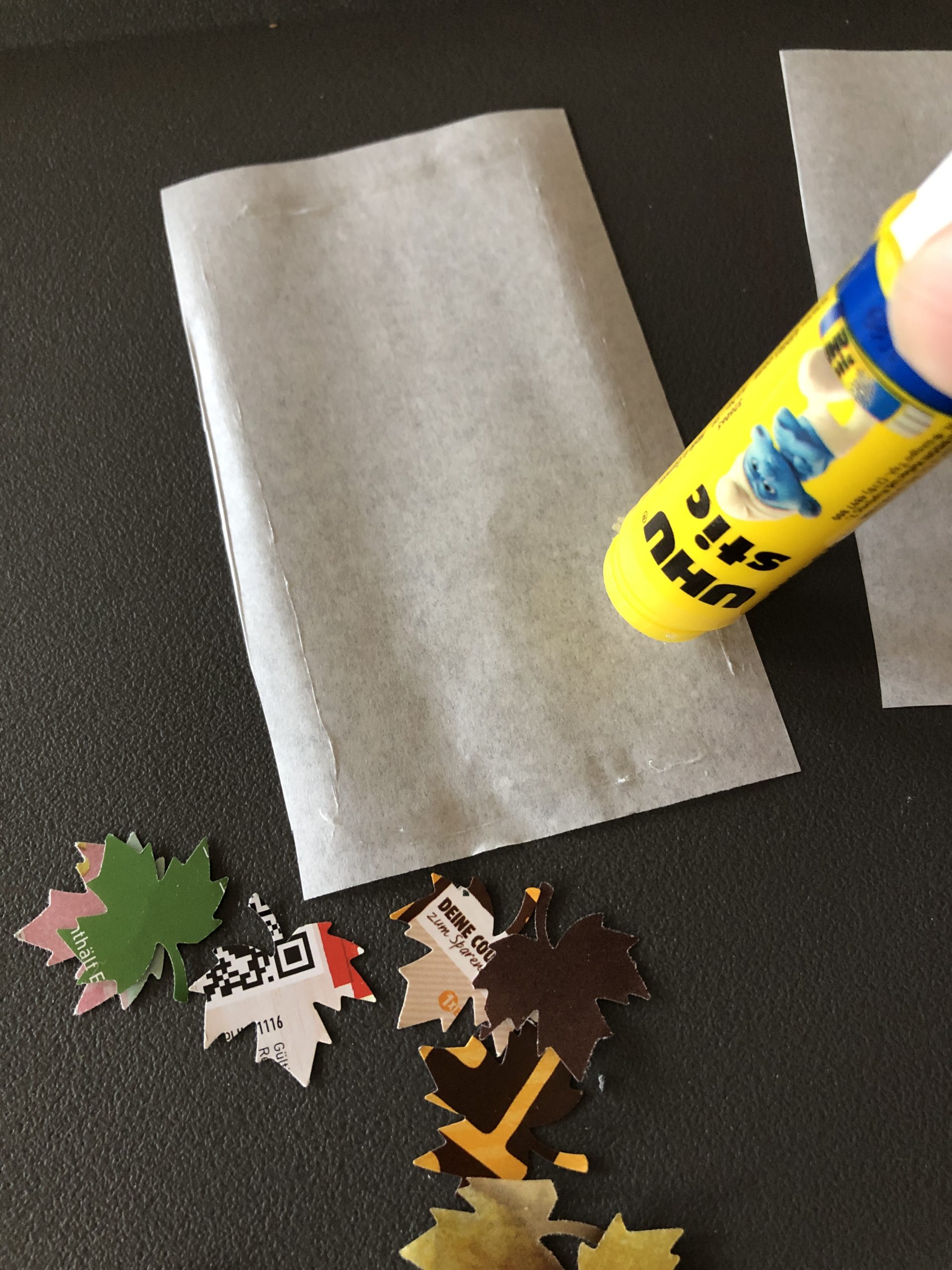 Bild zum Schritt 13 für das Bastel- und DIY-Abenteuer für Kinder: 'Bestreicht die Ränder der Butterbrotpapier-Zuschnitte mit Kleber und befestigt sie...'