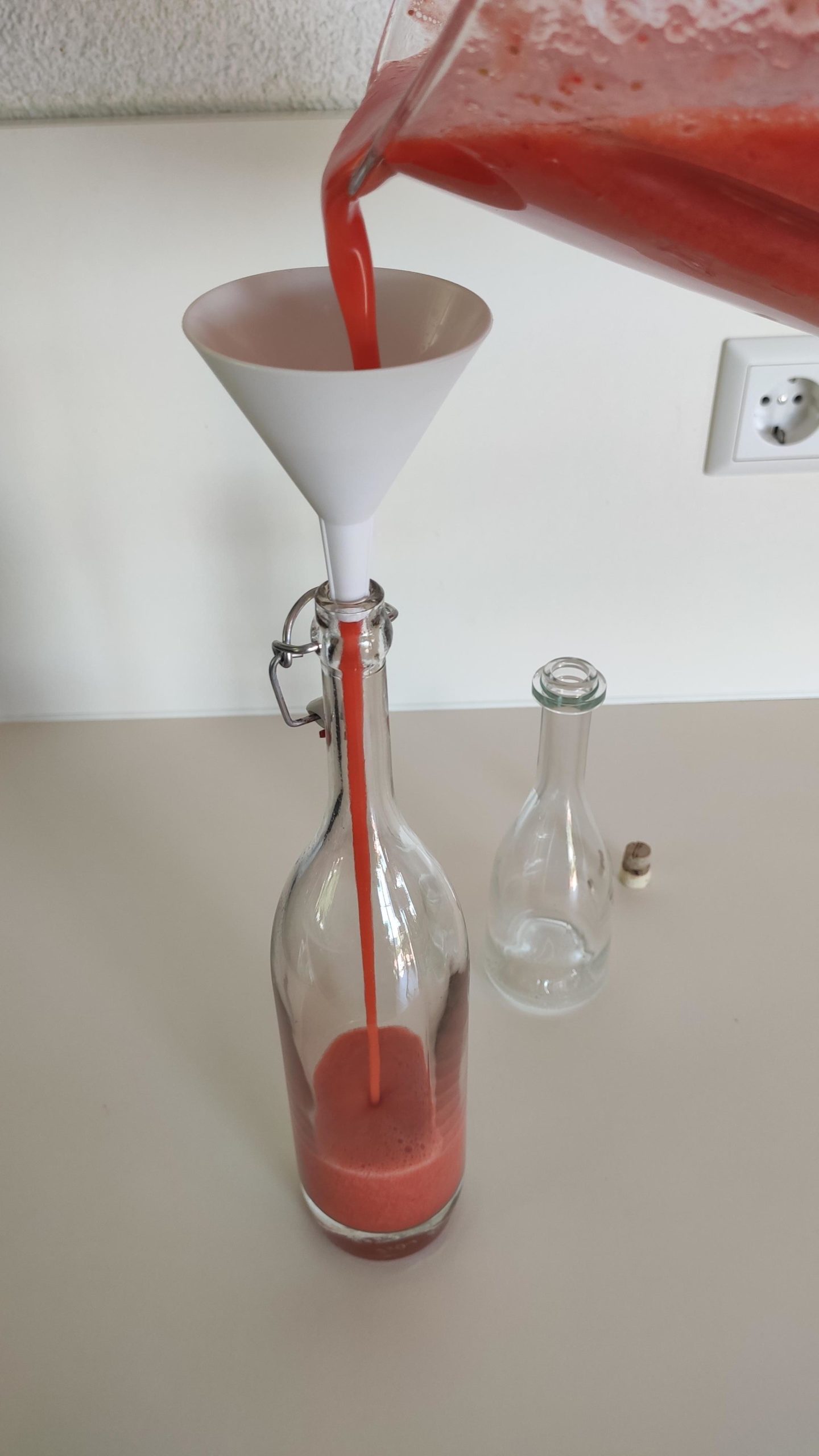 Bild zum Schritt 9 für die Kinder-Beschäftigung: 'Nun den Erdbeerlimes in ausgekochte Glasflaschen füllen. Dafür einen Trichter...'