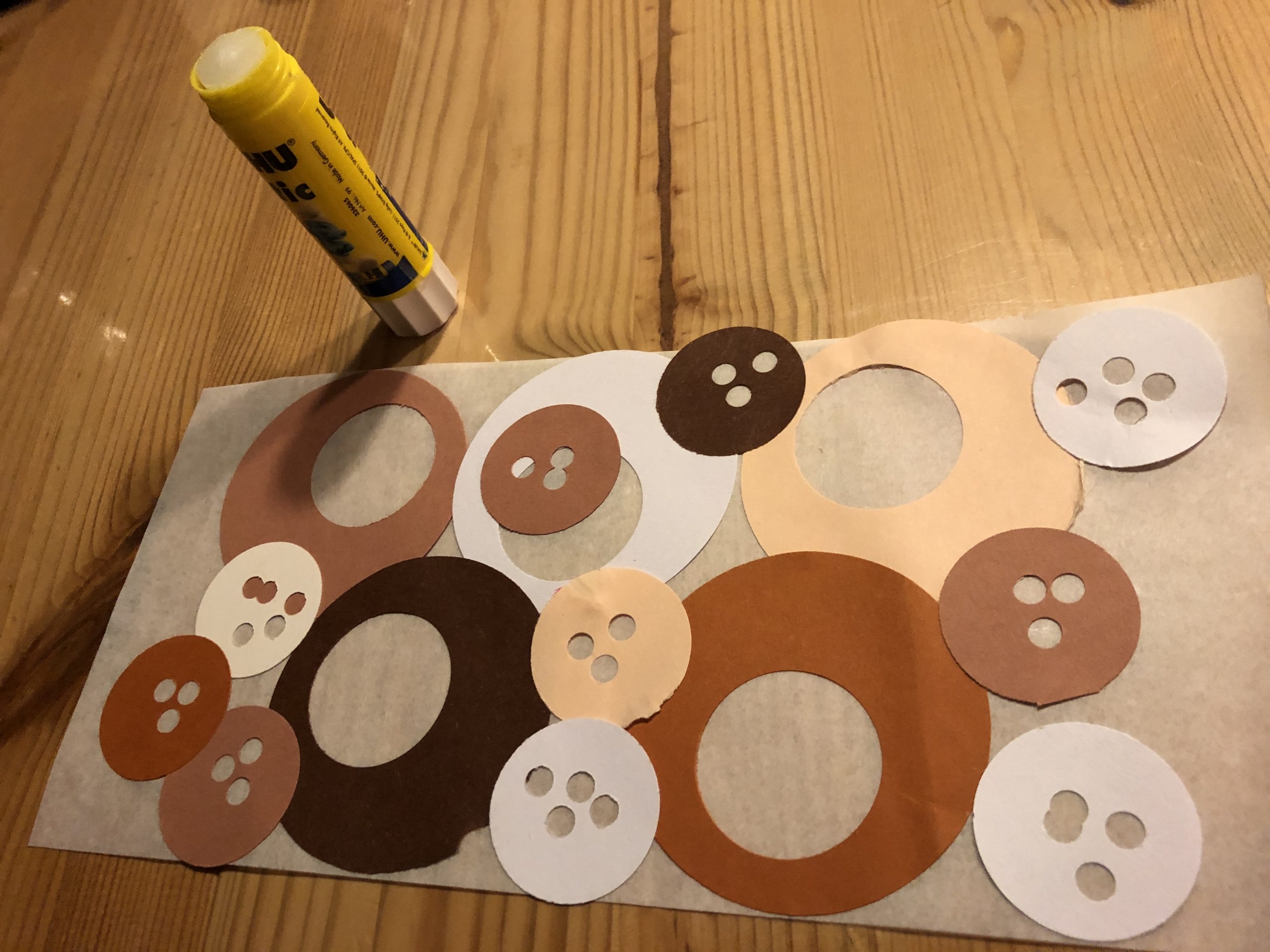 Bild zum Schritt 7 für das Bastel- und DIY-Abenteuer für Kinder: 'Jetzt klebt ihr alle Kreise auf das Butterbrotpapier.'