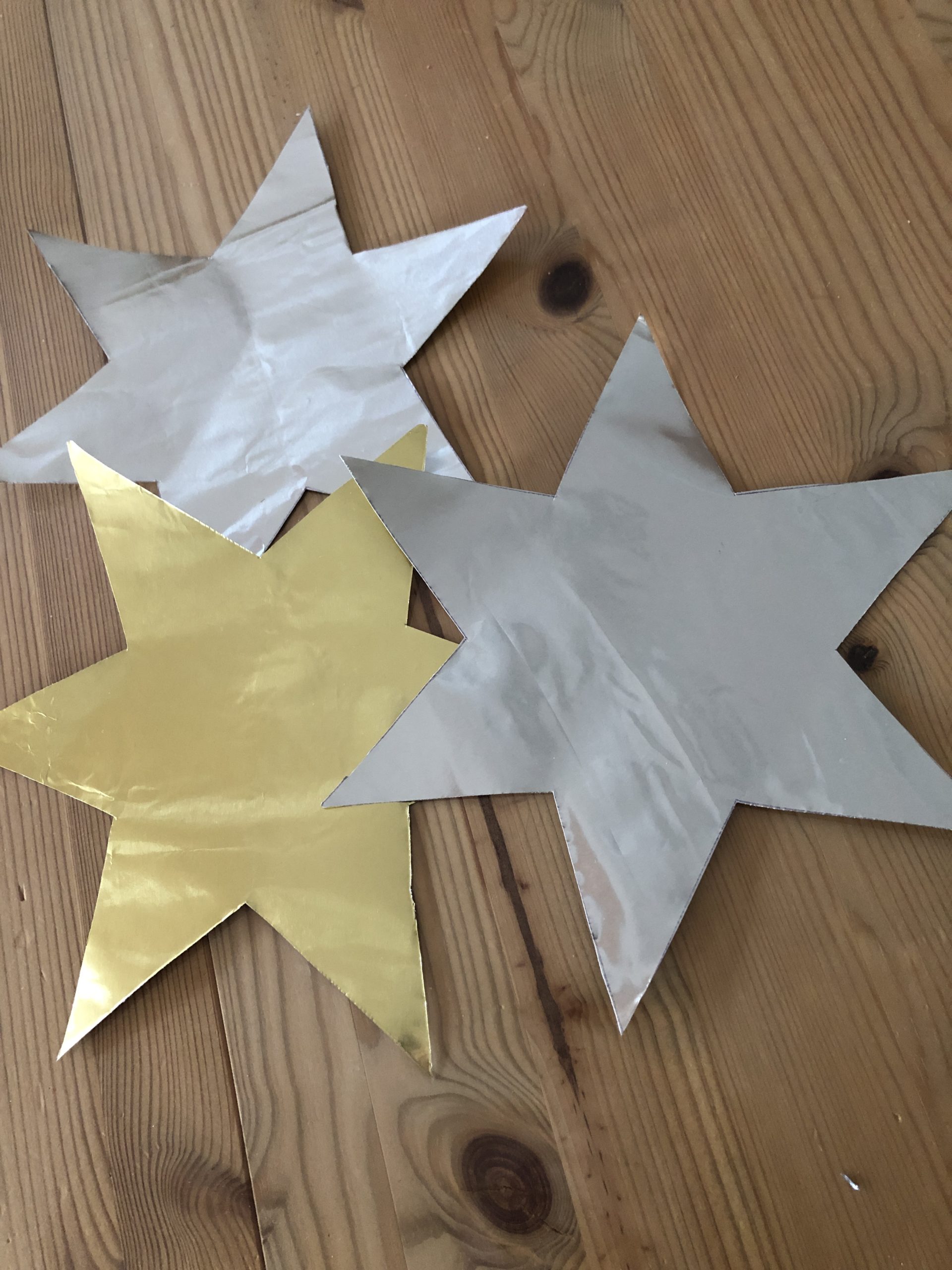2. Bild zum Schritt 4 für das Bastel- und DIY-Abenteuer für Kinder: 'Für jeden fertigen Klapperstern braucht ihr zwei Sterne aus Goldpapier.'