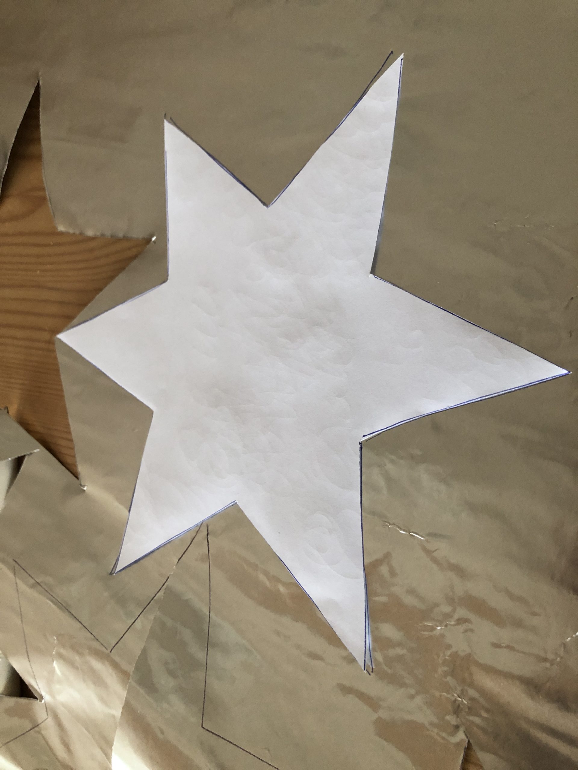 Bild zum Schritt 3 für das Bastel- und DIY-Abenteuer für Kinder: 'Übertragt nun die Sternschablone auf das Goldpapier.'