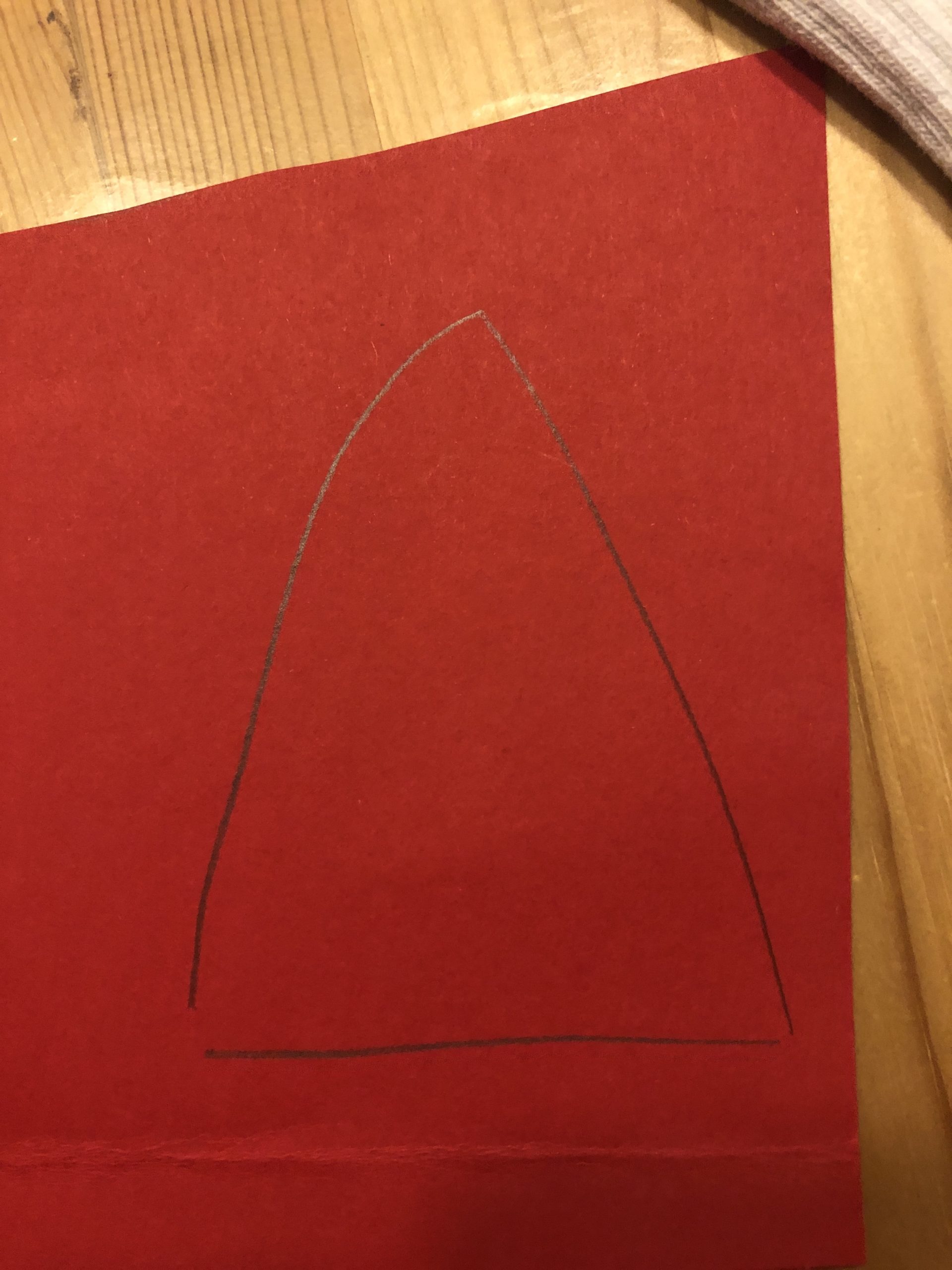 Bild zum Schritt 3 für das Bastel- und DIY-Abenteuer für Kinder: 'Auf den roten Fotokarton malt ihr jetzt eine Spitze Nikolausmütze...'